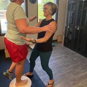 Ability Physical Therapy Owner Lori Swanton assists a client with her balance.